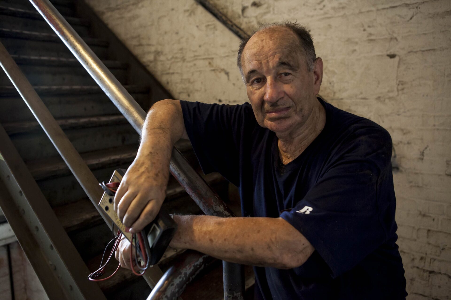 Edik Fishman climbing stairs to decommission the workshop's electrical system