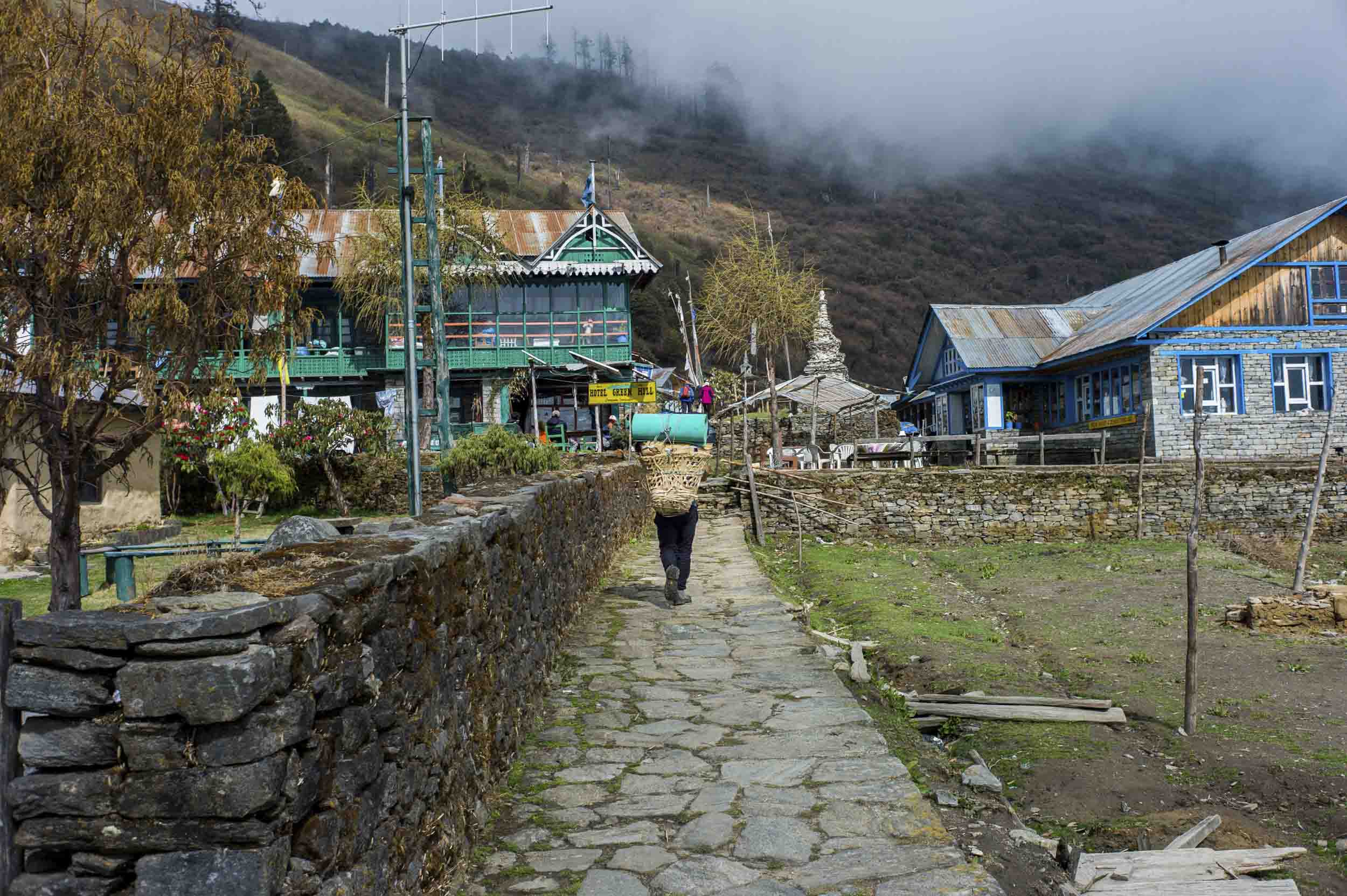 A porter carrying trekking supplies arrives to Sing Gompa, a mountain town in Nepal’s highlands, 2012