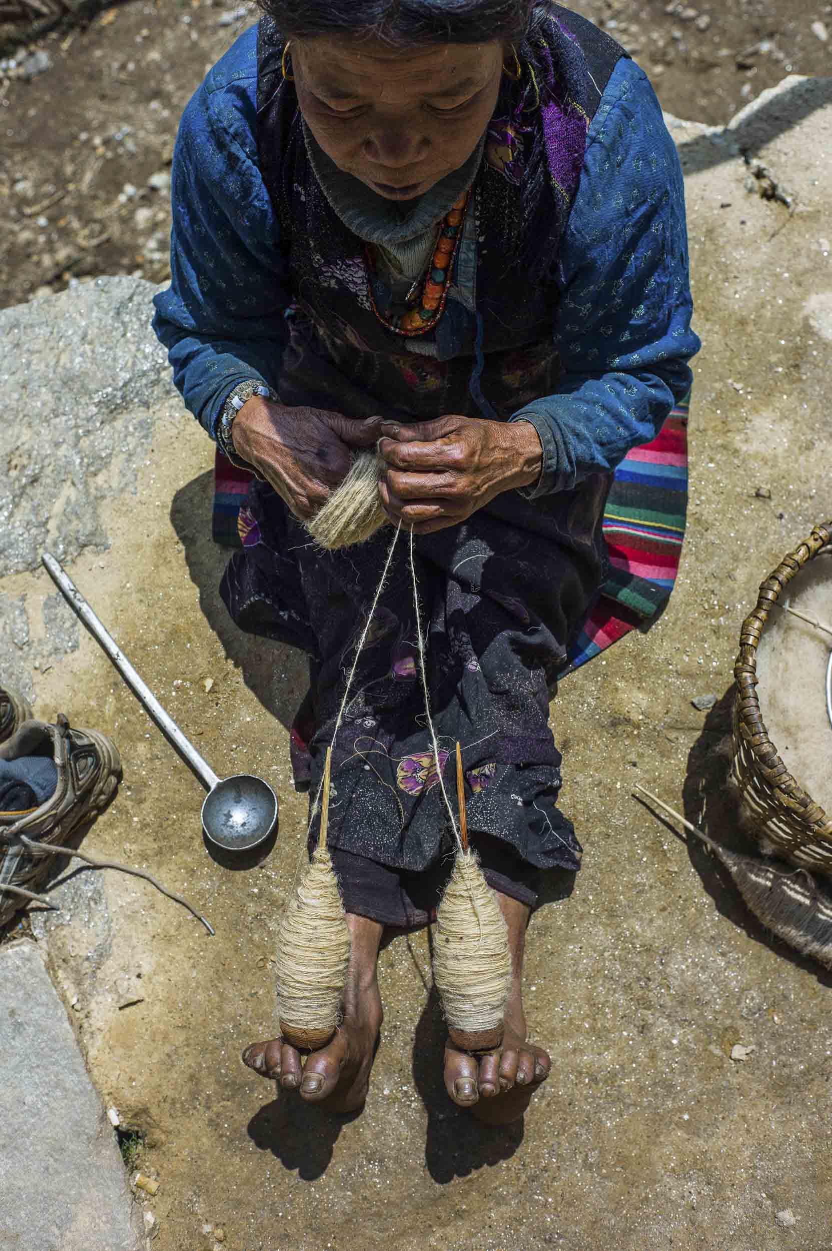 Hand spinning wool in a small village between the highland villages of Dunche and Sing Gompa