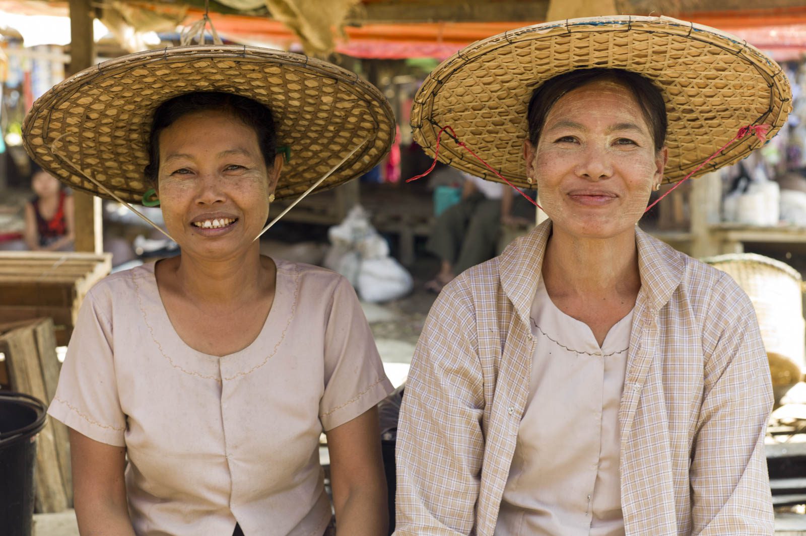 Shoppers with faces adorned with the sun-protecting thanaka in a Taunggok, Myanmar market, 2012
