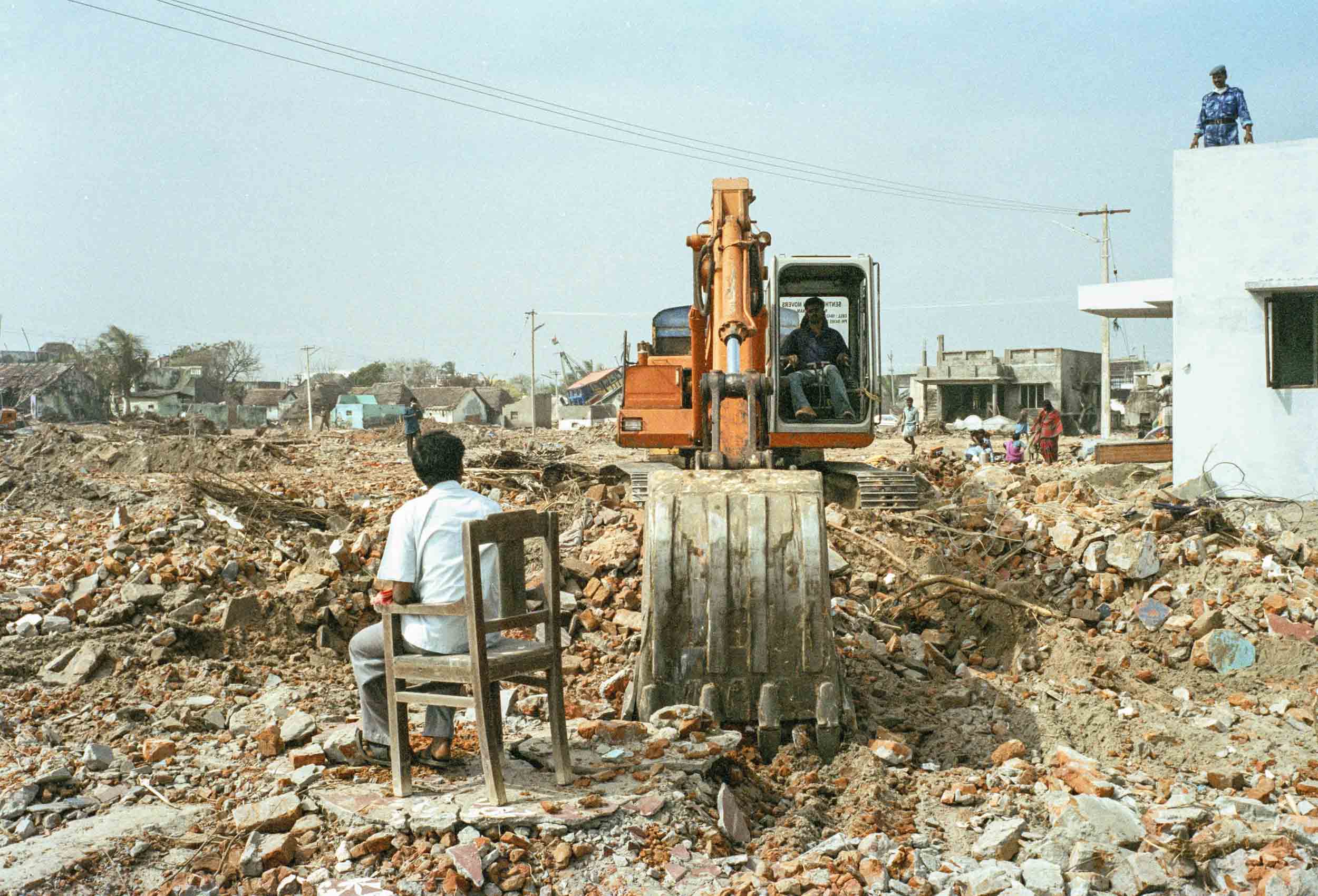 Work crews operating heavy machinery clean up the devastated landscape two weeks after the tsunami struck. Nagapattinam, India, 2005